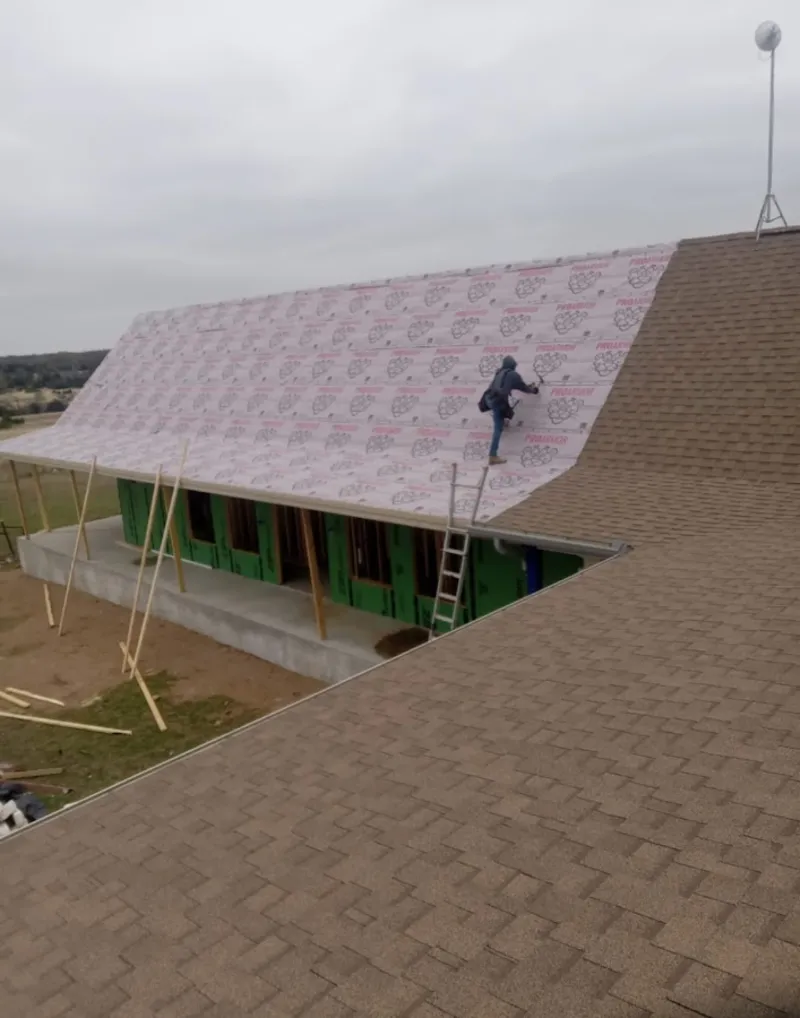 Worker preparing underlayment for a metal roof installation in Helena Valley Southeast